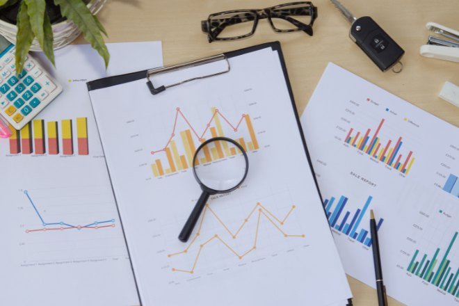 Hình ảnh người đang phân tích biểu đồ và dữ liệu marketing trên máy tính bảng
