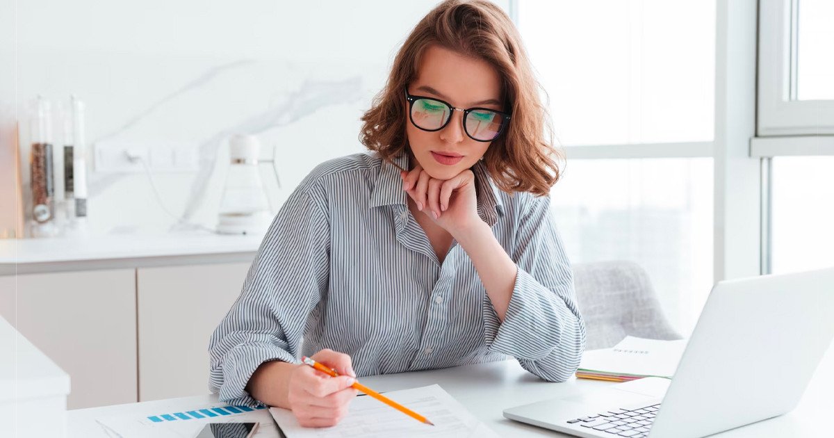 Một người đang ngồi viết kế hoạch trên giấy, biểu thị quá trình xây dựng kế hoạch chi tiết và có hệ thống để quản lý thời gian hiệu quả
