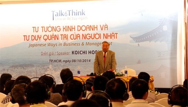 Người đàn ông mặc vest chia sẻ với khán phòng