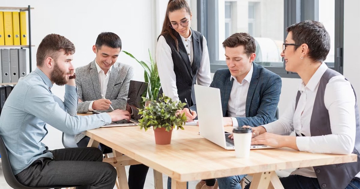 Các kỹ năng mà cử nhân ngành Quản trị kinh doanh cần trang bị - Hình ảnh một đội nhóm đang làm việc trên máy tính với các biểu đồ