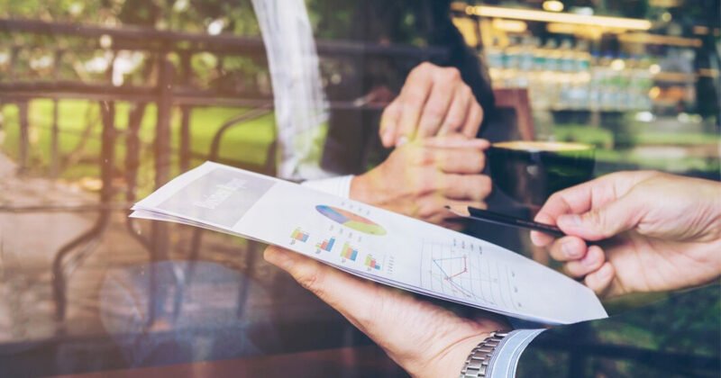 Chuyên gia đang phân tích báo cáo tài chính với biểu đồ và số liệu