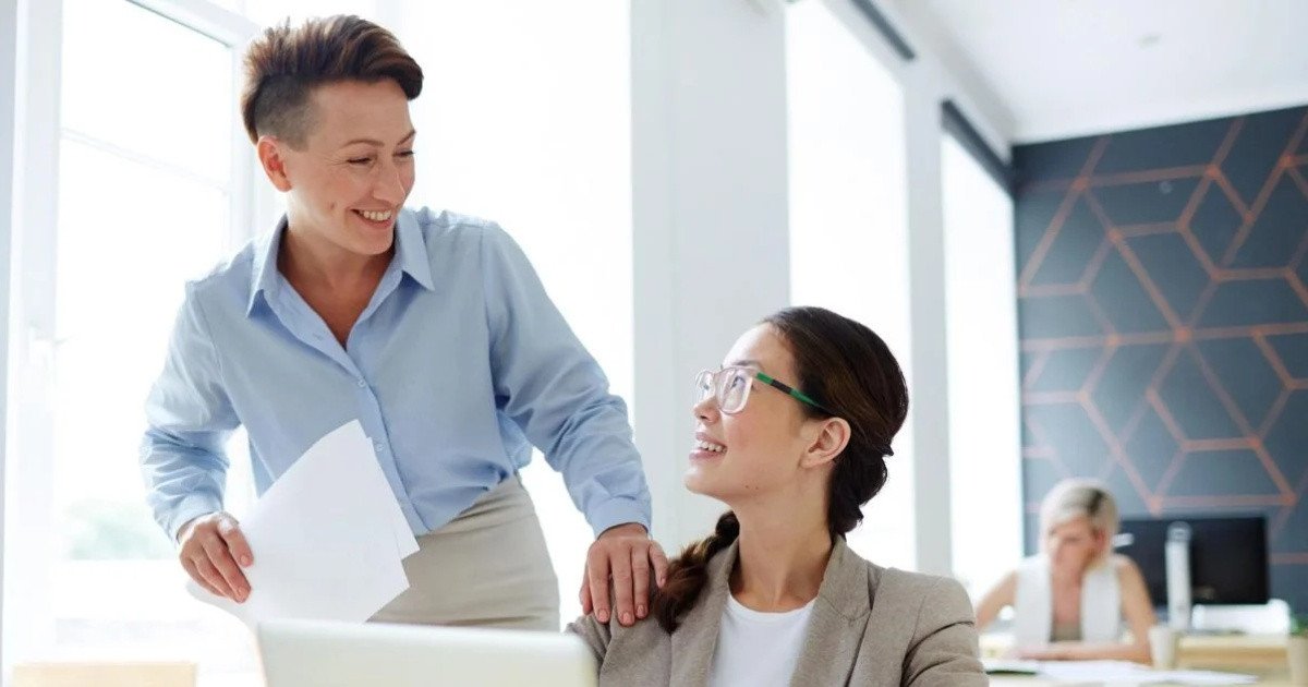 Hai đồng nghiệp đang trao đổi tích cực, thể hiện tầm quan trọng của trí tuệ cảm xúc trong nâng cao hiệu suất làm việc