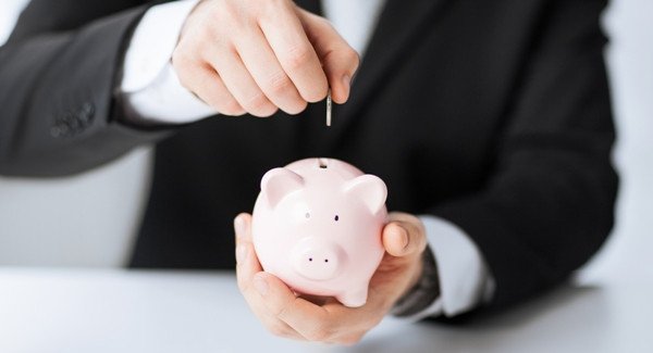 Người đàn ông bỏ tiền vào ống heo tiết kiệm