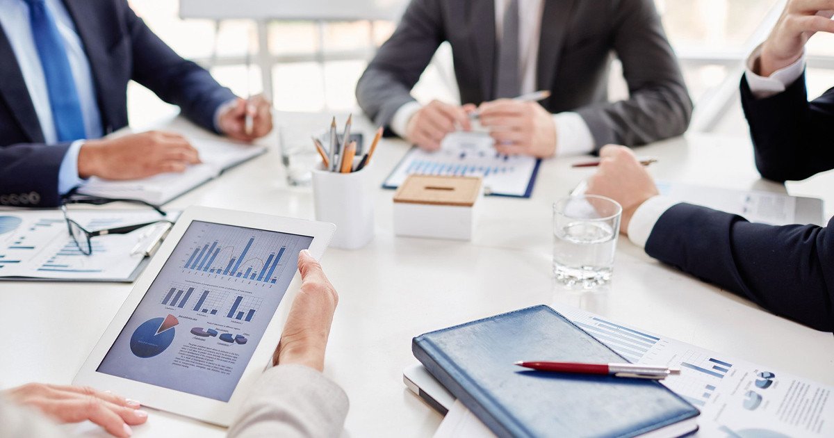 Người làm sales đang trao đổi qua điện thoại và ghi chú trên máy tính